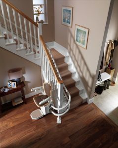 aerial view of a homes curved staircase with a stairlift sitting at the bottom of the stairs
